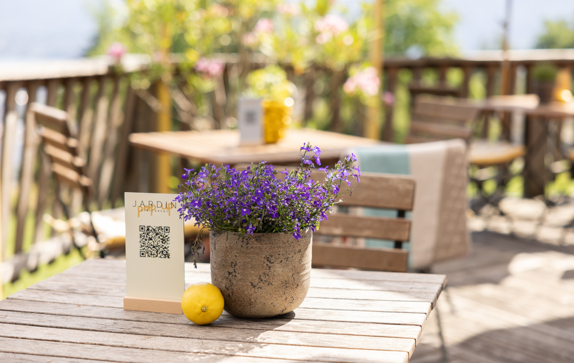 Lavendeldekoration auf Terrassentisch mit begrüntem Hintergrund und Holzgeländer, Terrasse Sorell Hotel