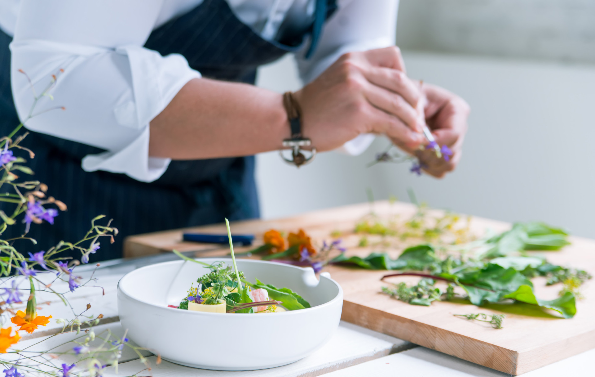 Küchenchef hält Kräuter in der Hand und bereitet das Essen vor