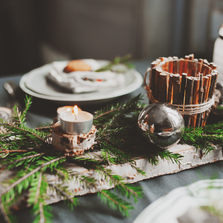 Weihnachtlich gedeckter Tisch mit Tannenzweigen und Tellern, 