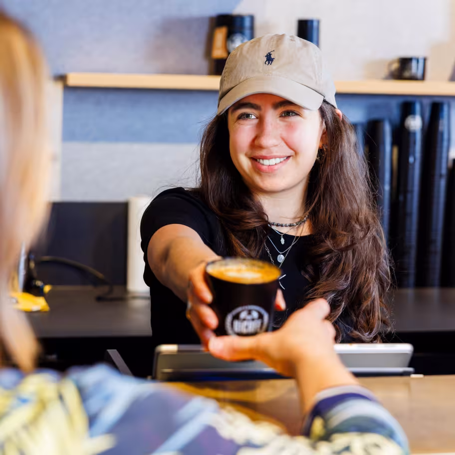 Junge Frau serviert einen Kaffee to go