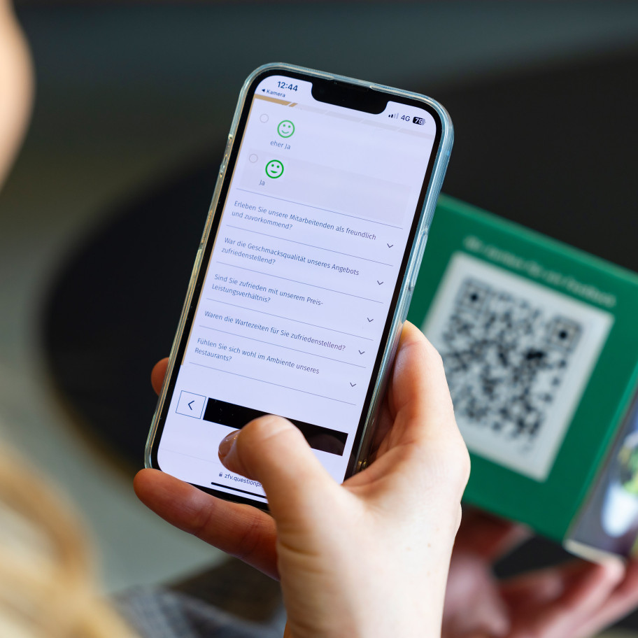 Handy scannt einen QR-Code zu einer Gästeumfrage