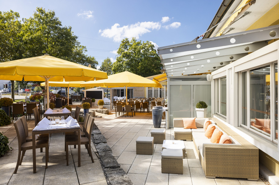 Terrasse mit Tischen, Stühlen und Sonnenschirmen des Sorell Hotels Sonnental