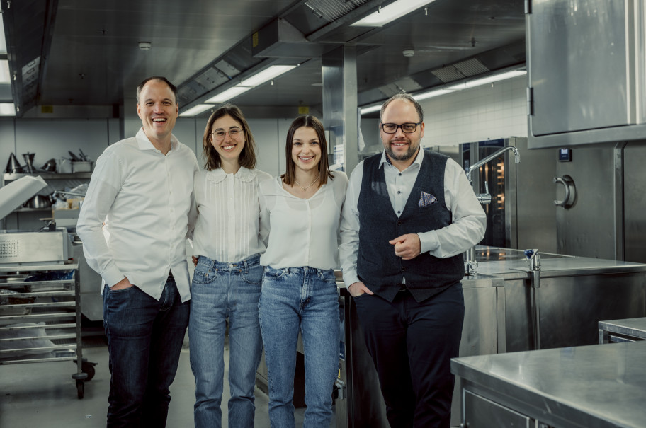 Ein Team von vier Menschen zwei Frauen, zwei Männer blickt lächelnd in die Kamera