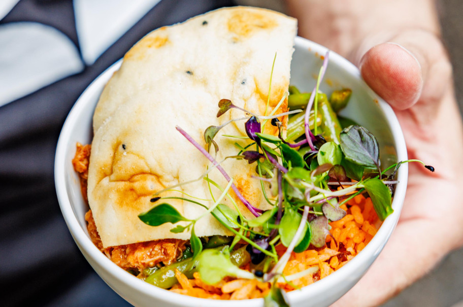 Weibliche Hand mit Schale voll Essen
