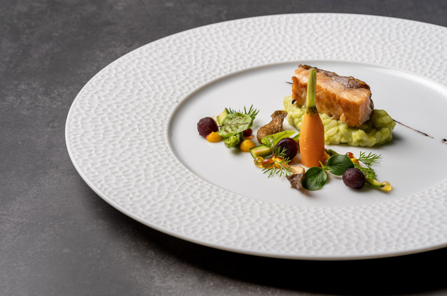 Gericht mit Lachs, Risotto und Gemüse in einer modernen Anrichteweise