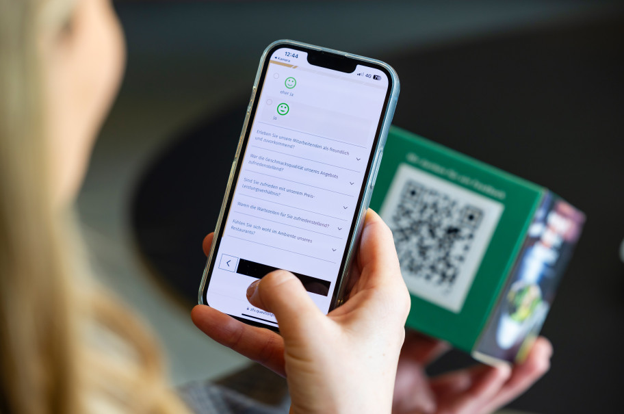 Handy scannt einen QR-Code zu einer Gästeumfrage
