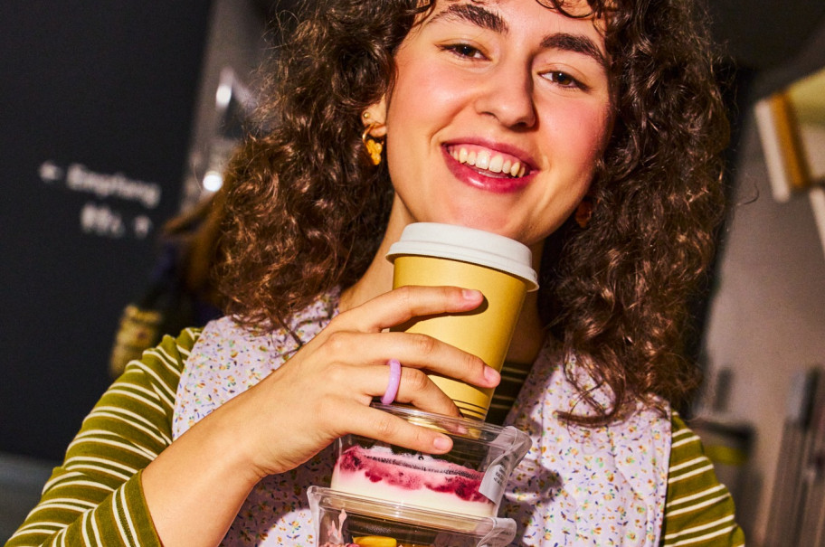 Junge Frau trägt Bichermüesli und Joghurtbecher