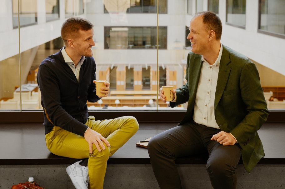 Zwei Männer sitzen auf einer Fensterbank und tauschen sich aus