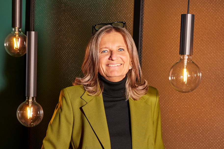 Frau blickt lächelnd in die Kamera