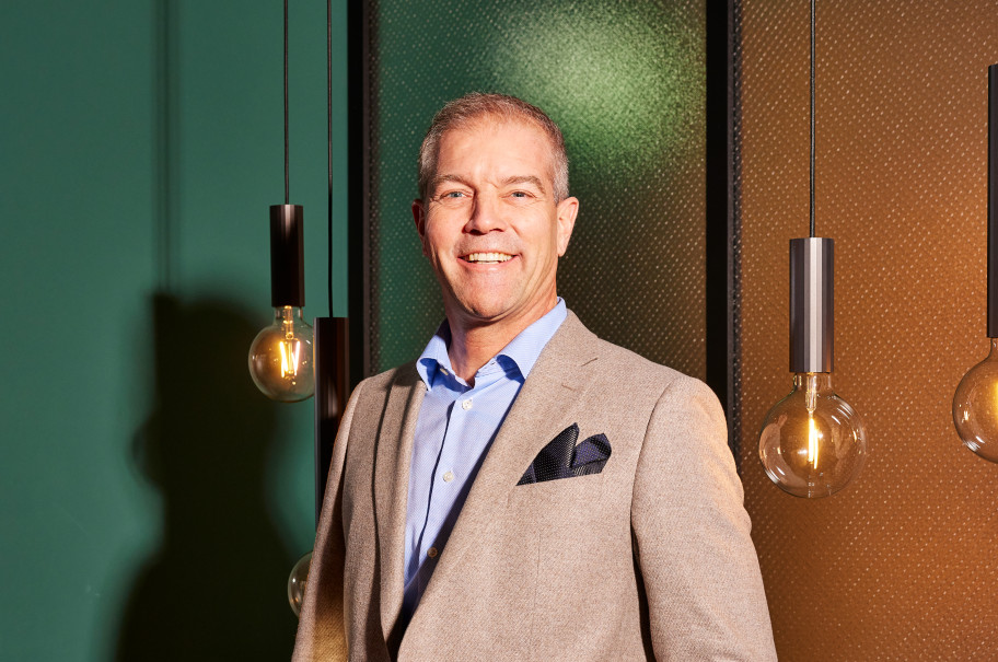 Mann blickt lächelnd in die Kamera