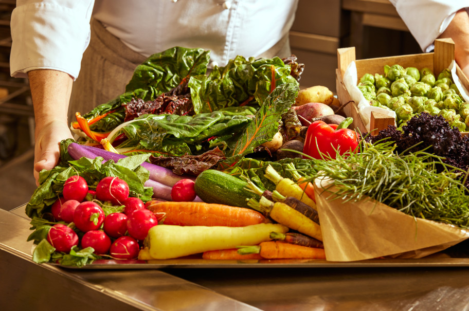 Koch hält Plateau mit frischem Gemüse