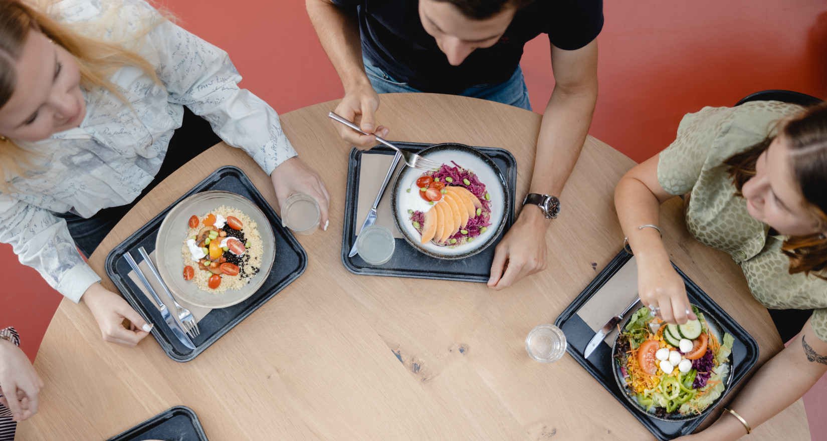 Vier Personen, die gemeinsam an einem Tisch am Essen sind