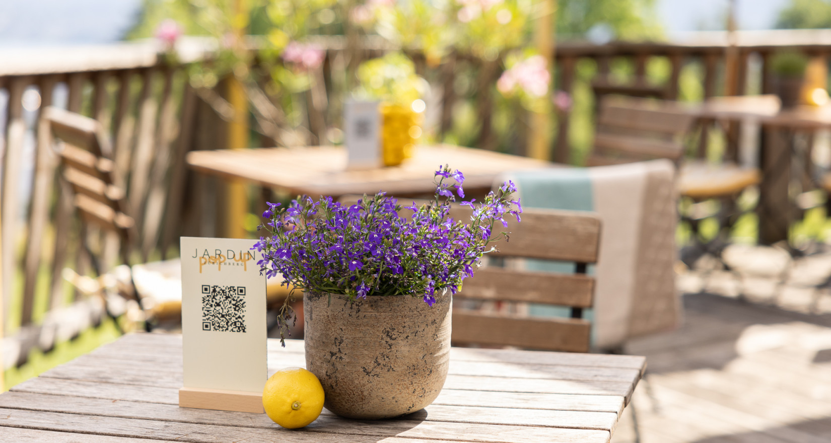 Lavendeldekoration auf Terrassentisch mit begrüntem Hintergrund und Holzgeländer, Terrasse Sorell Hotel