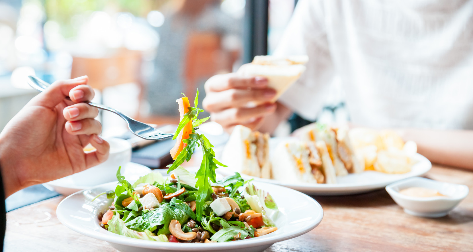 Personen essen Salat am Tisch