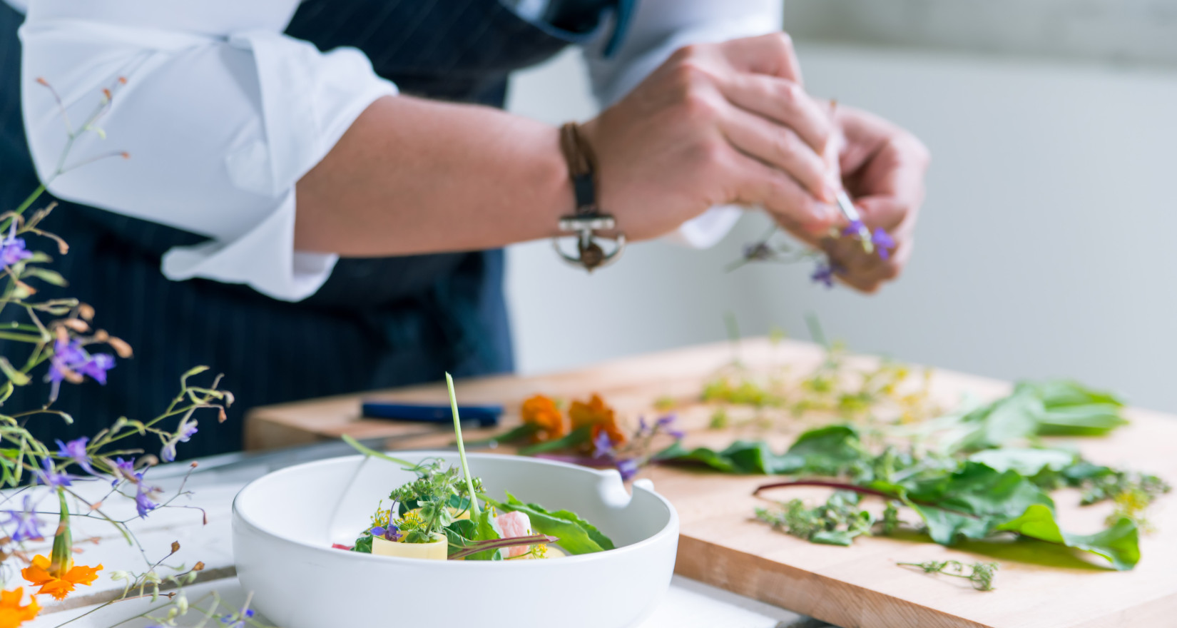 Küchenchef hält Kräuter in der Hand und bereitet das Essen vor