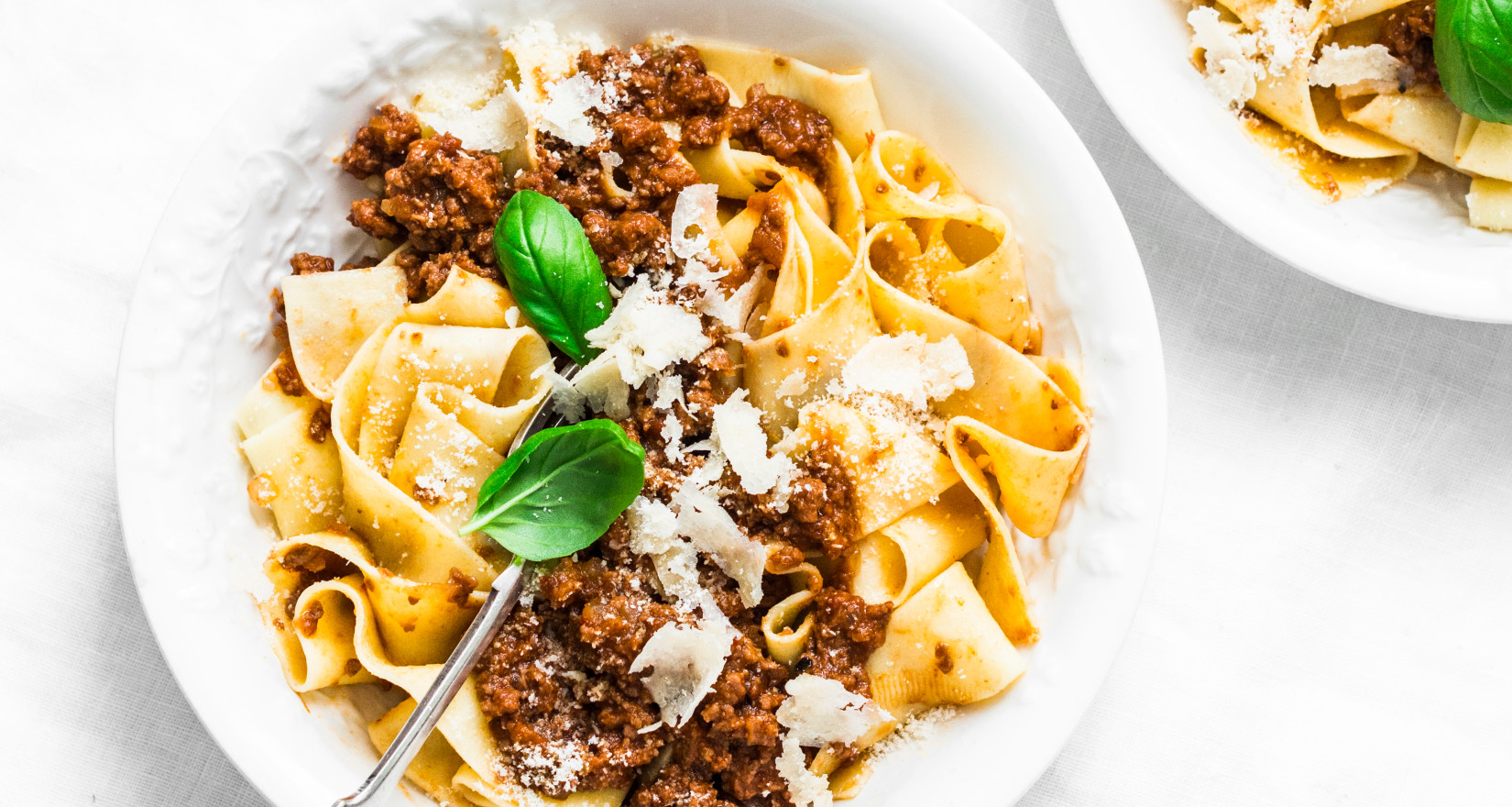 Aufnahme von zwei Tellern mit Pasta Bolognese und Parmesan