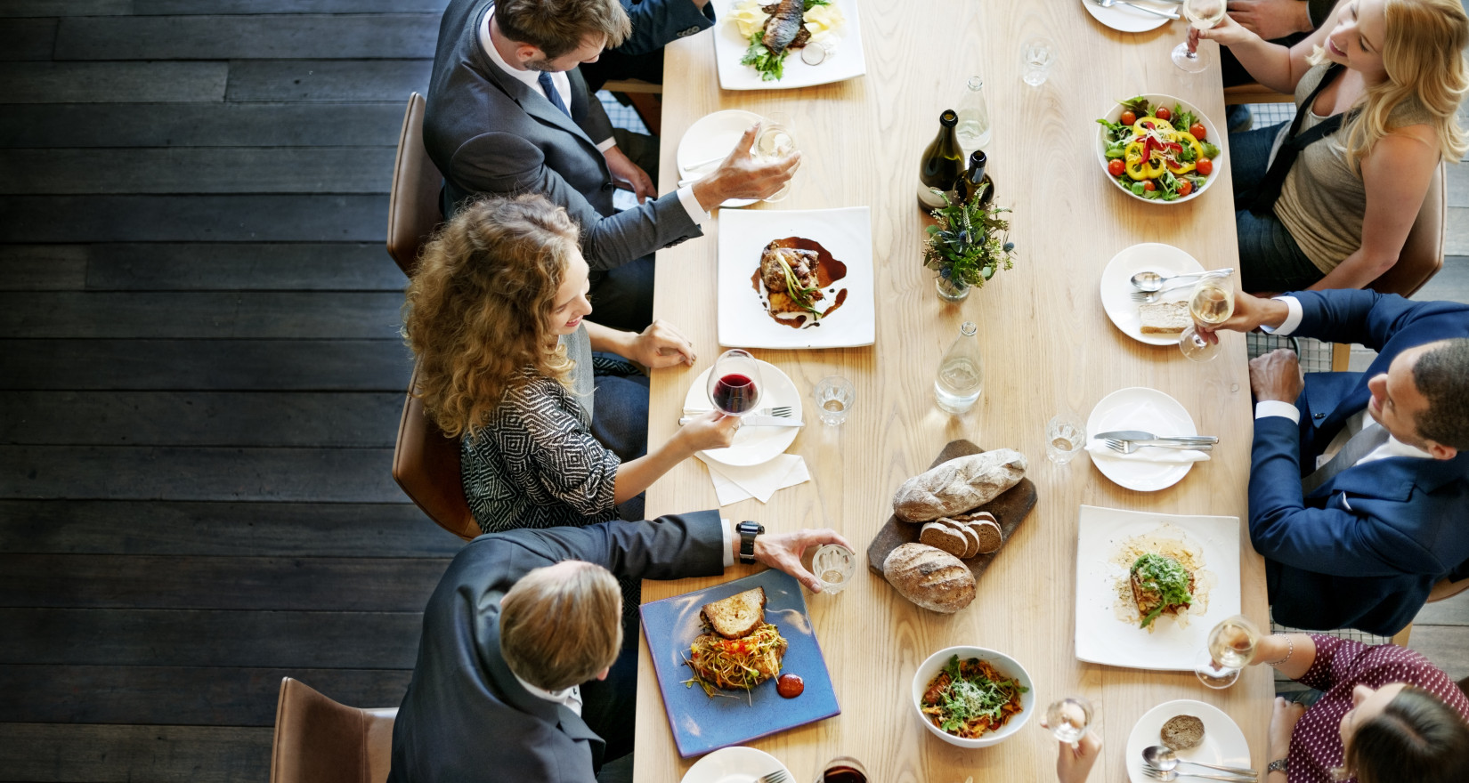 Personen an einem langen Tisch beim Mittagessen