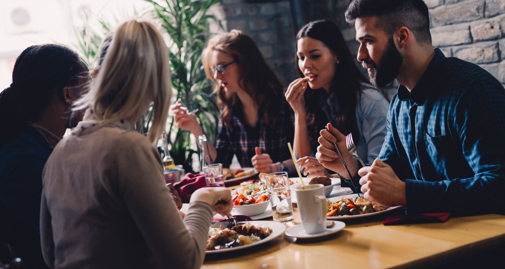 Gäste eines Restaurants an einem Tisch am Mittagessen