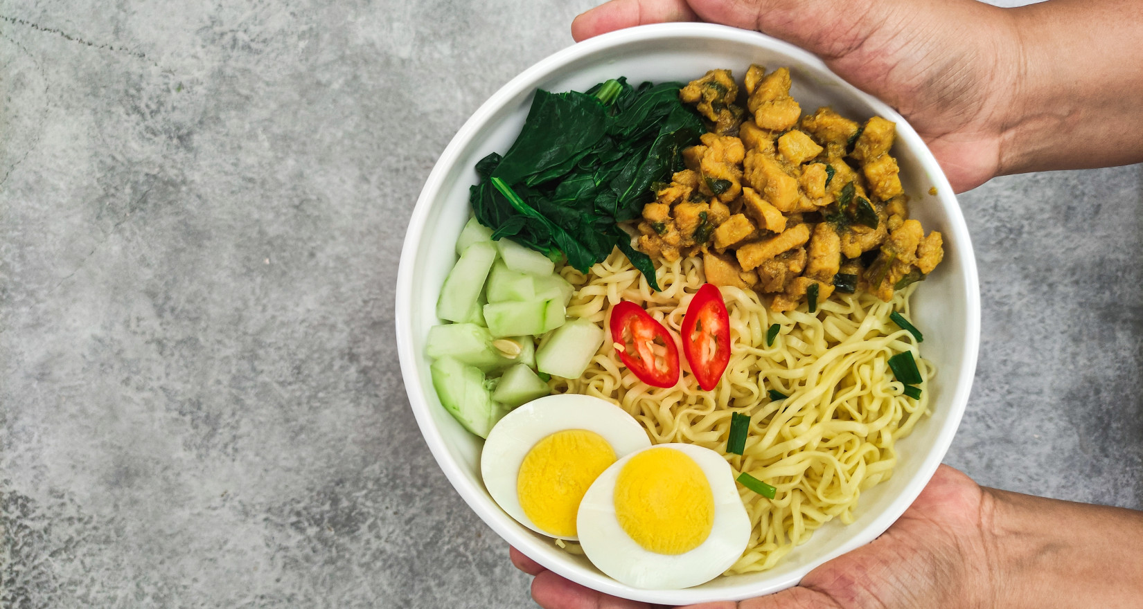 Person hält eine vegetarische Bowl in der Hand