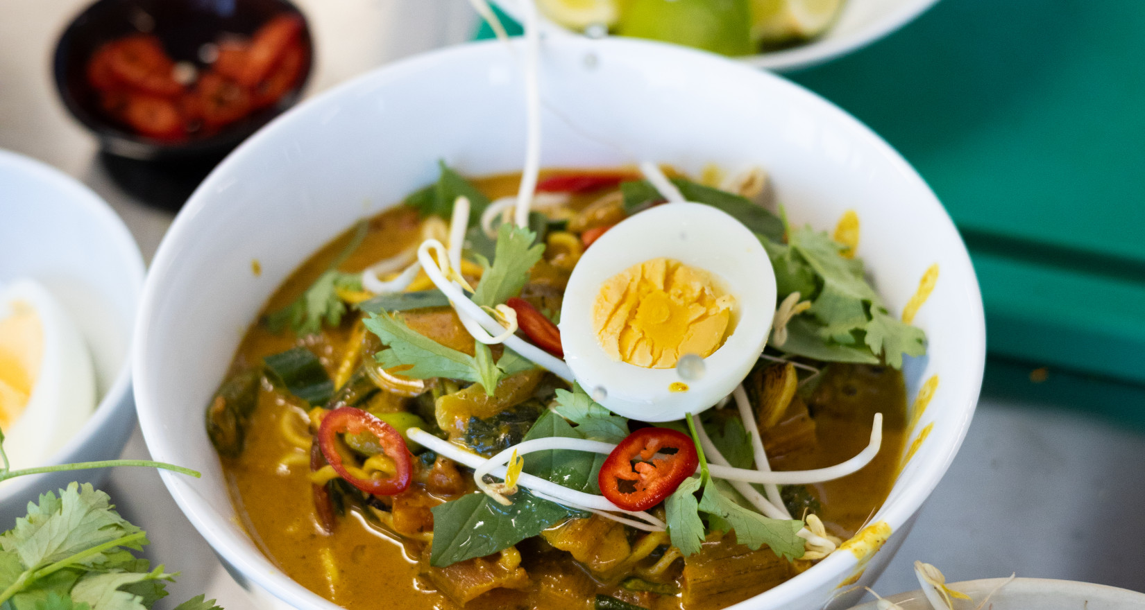 Hand bereitet asiatische Nudelsuppe zu