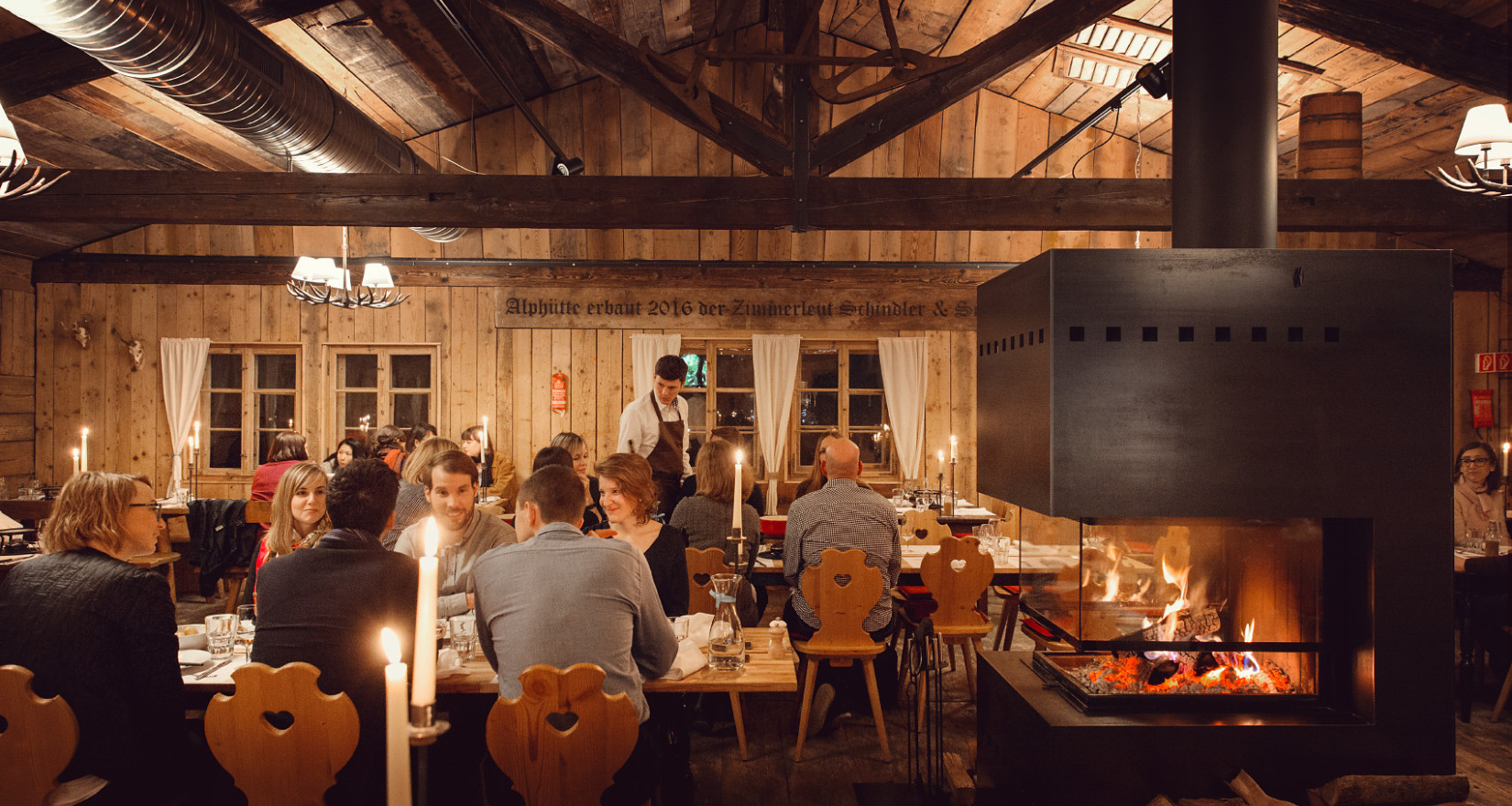 Chaletstil mit Holzvertäfelung und Menschen an Tischen