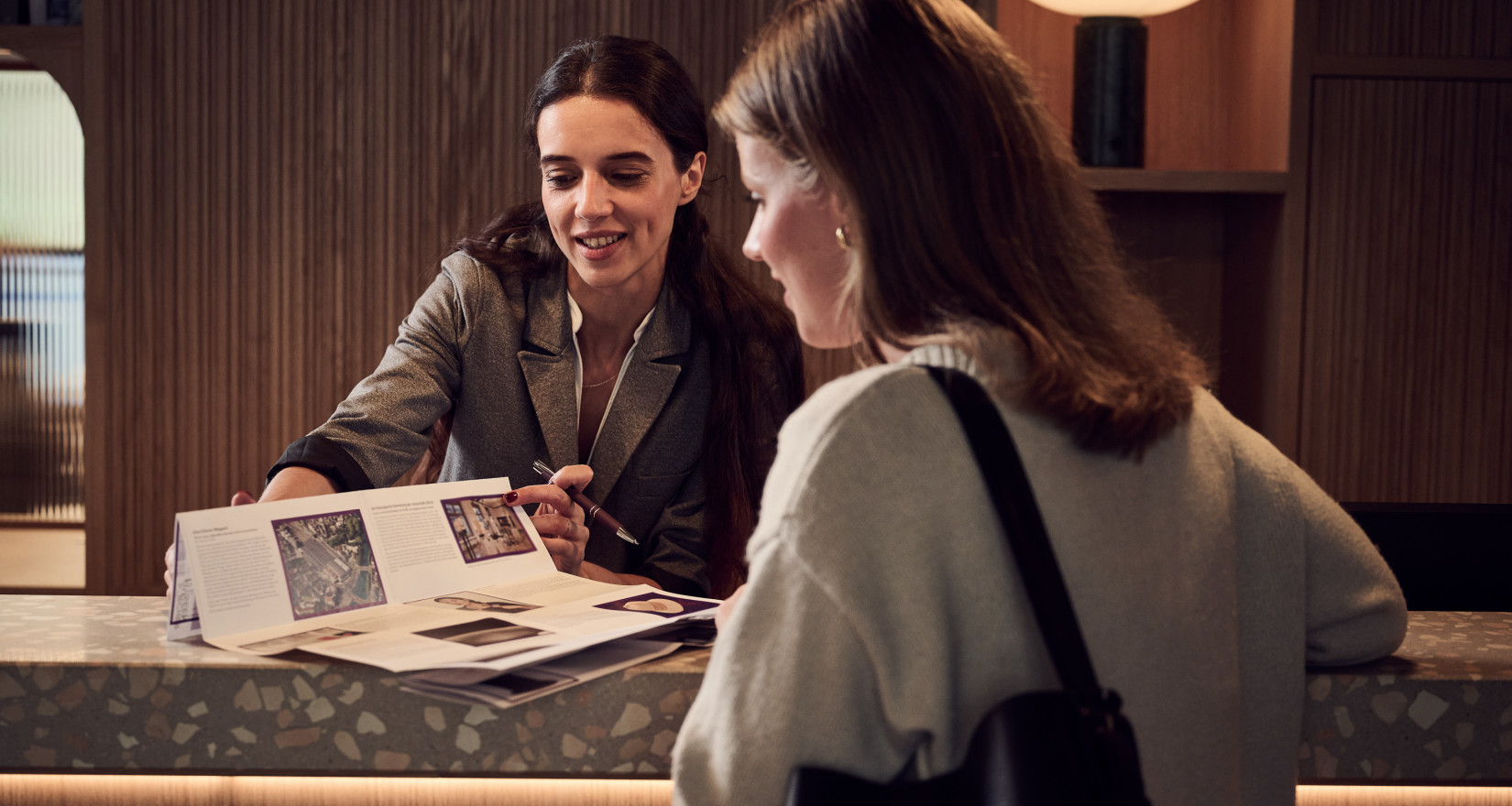 Frau beim Check-in an einer Hotelrezeption