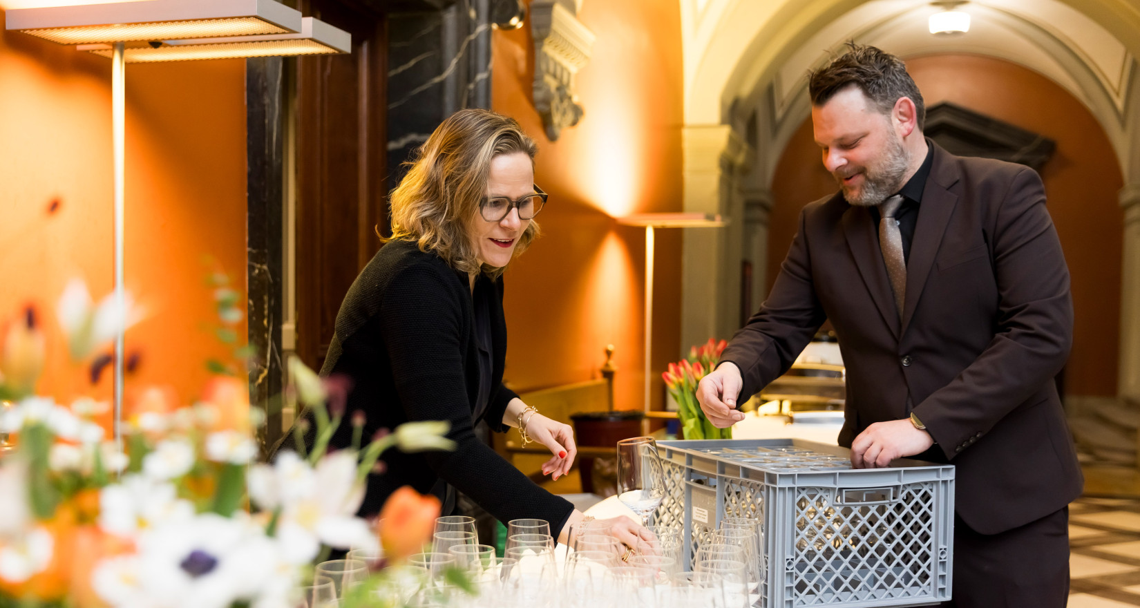 Zwei Personen bauen ein Buffet auf