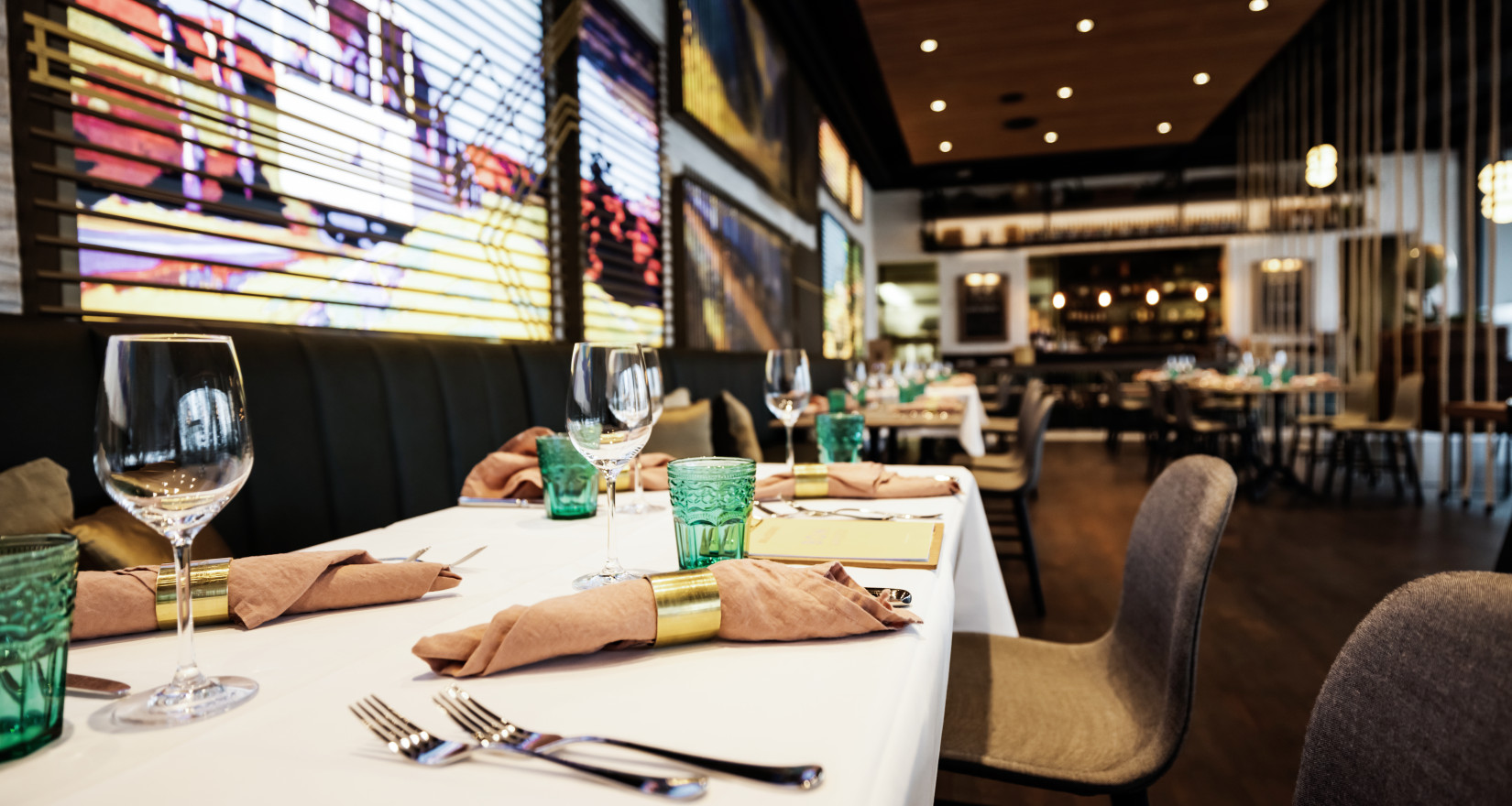 Innenansicht Brasserie im Verkehrshaus mit gedecktem Tisch und Bildern von Mobilität an der Wand
