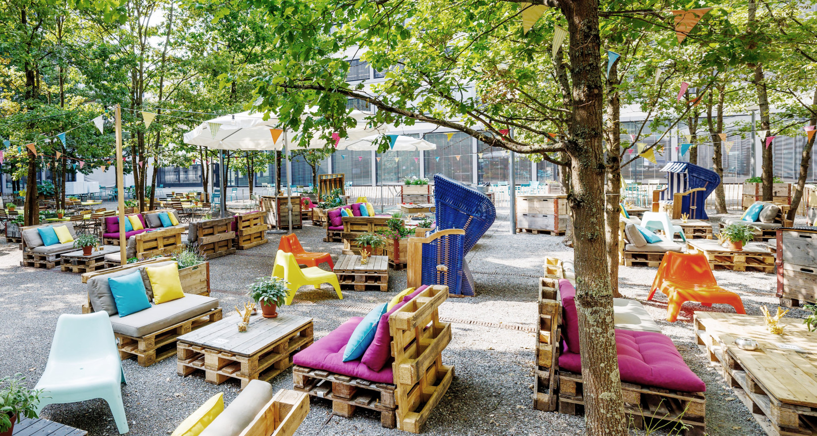 Bunter Sommergarten im Innenhof des Axa Superblocks mit DIY-Möbeln und Foodtrucks