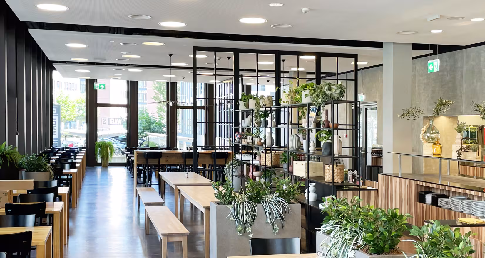 Innenansicht des Restaurants Wagi S mit Tischen, Stühlen und Blick auf die Fensterfront