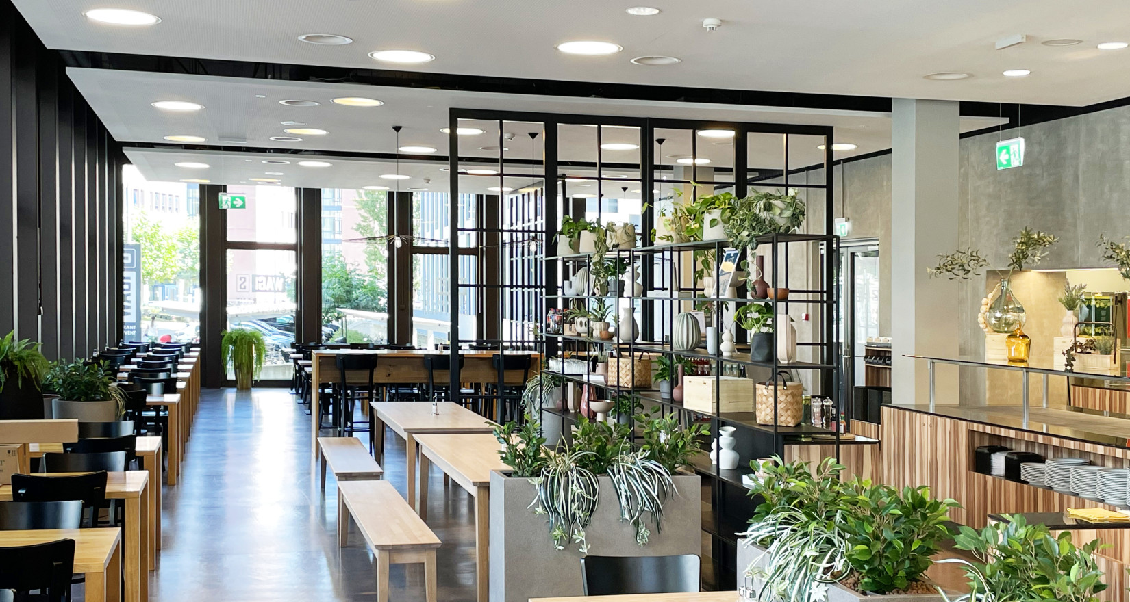 Innenansicht des Restaurants Wagi S mit Tischen, Stühlen und Blick auf die Fensterfront