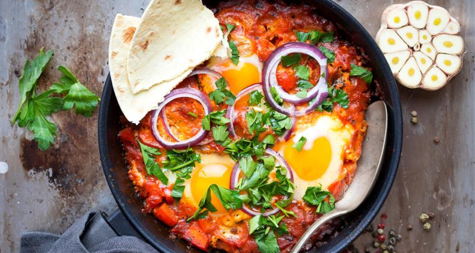 Pfanne mit Shakshuka und Fladenbrot