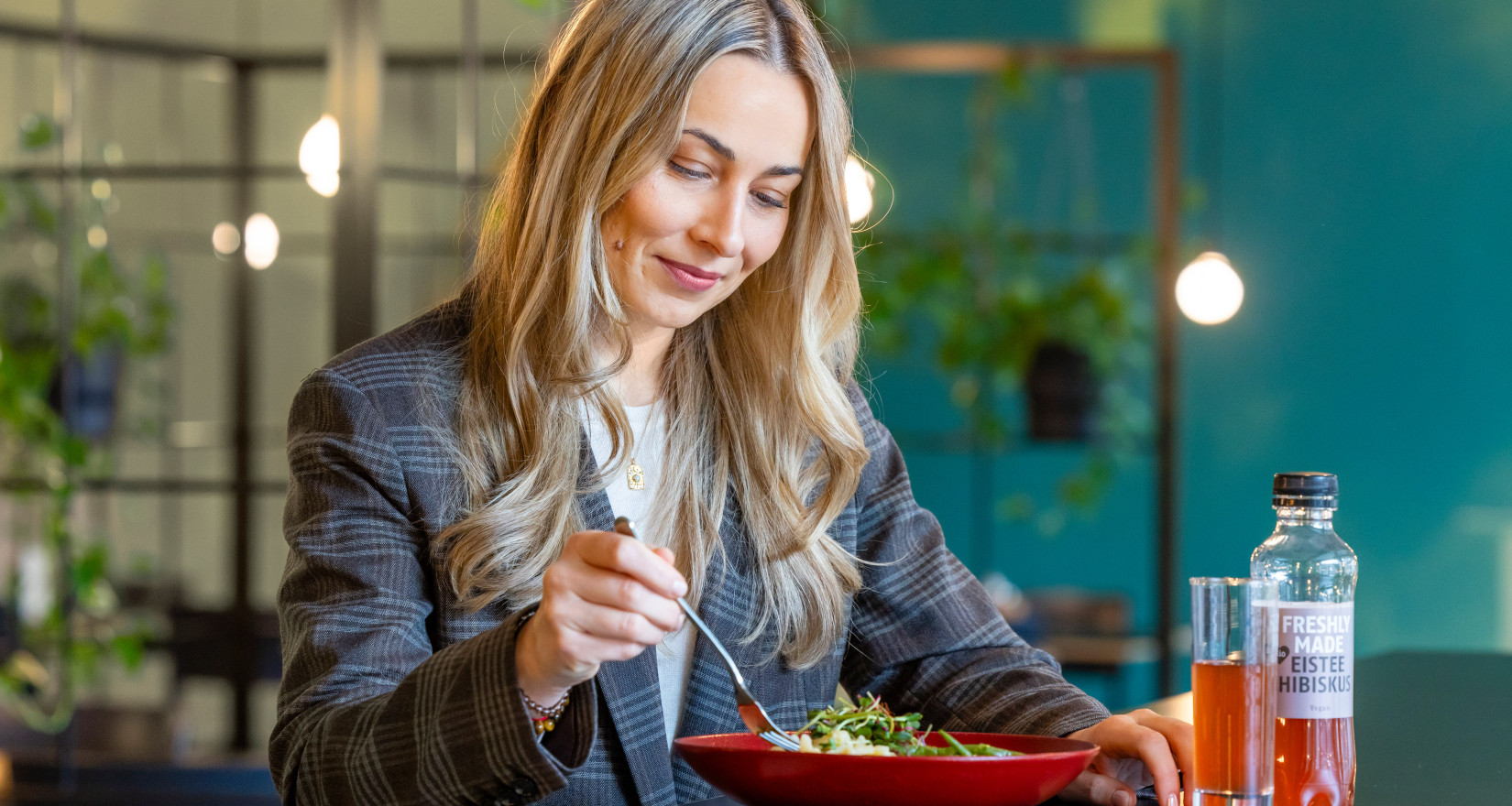 blond women eating a salad in a bowl