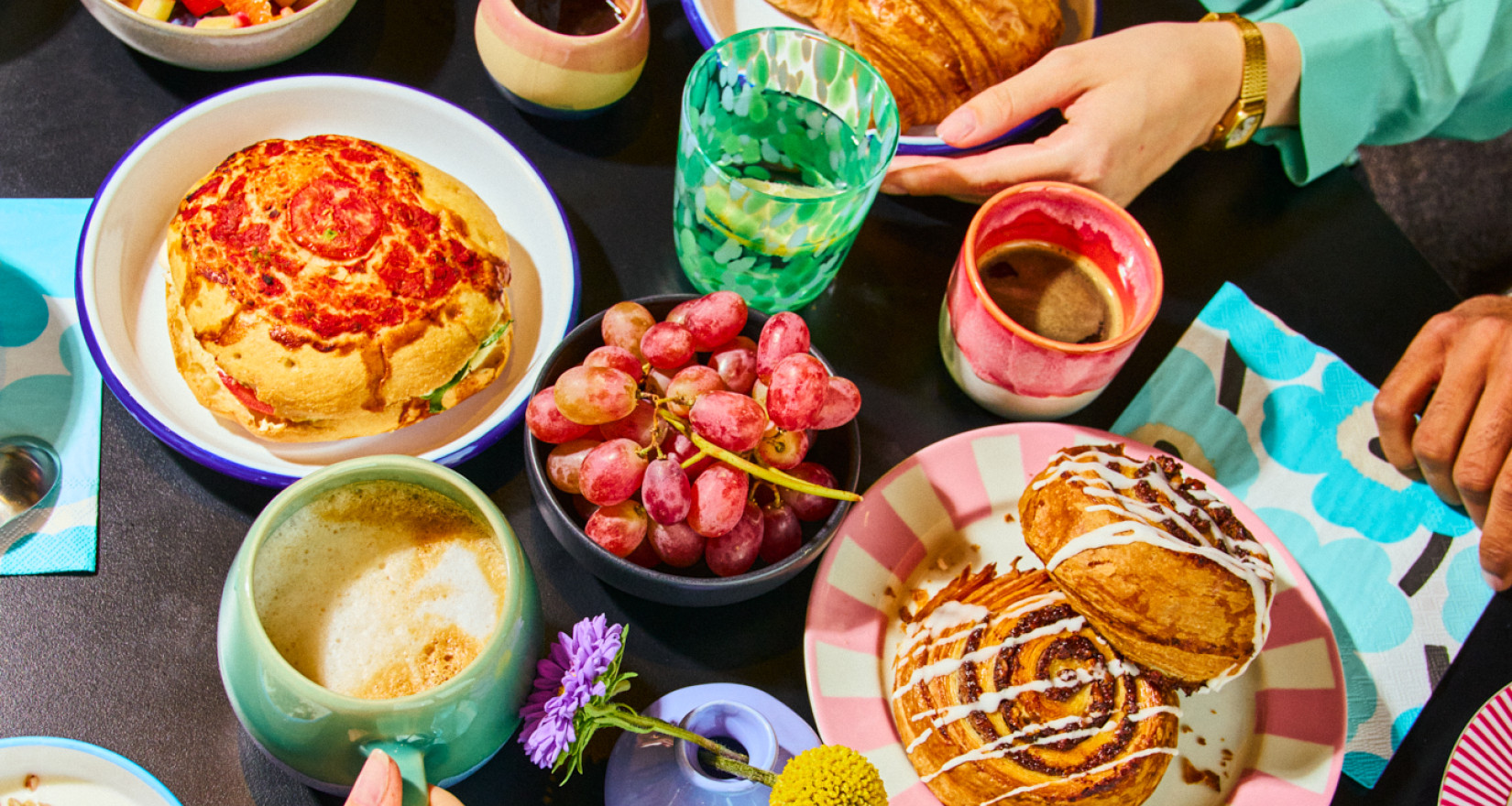 Gedeckter Tisch mit Händen bei einem Frühstück
