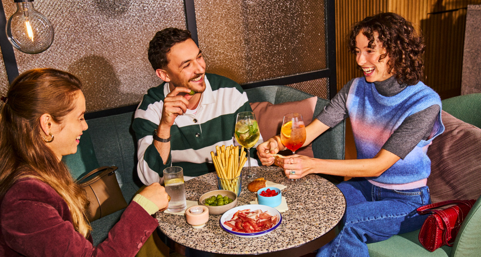 Drei Personen beim Apero an einem Tisch