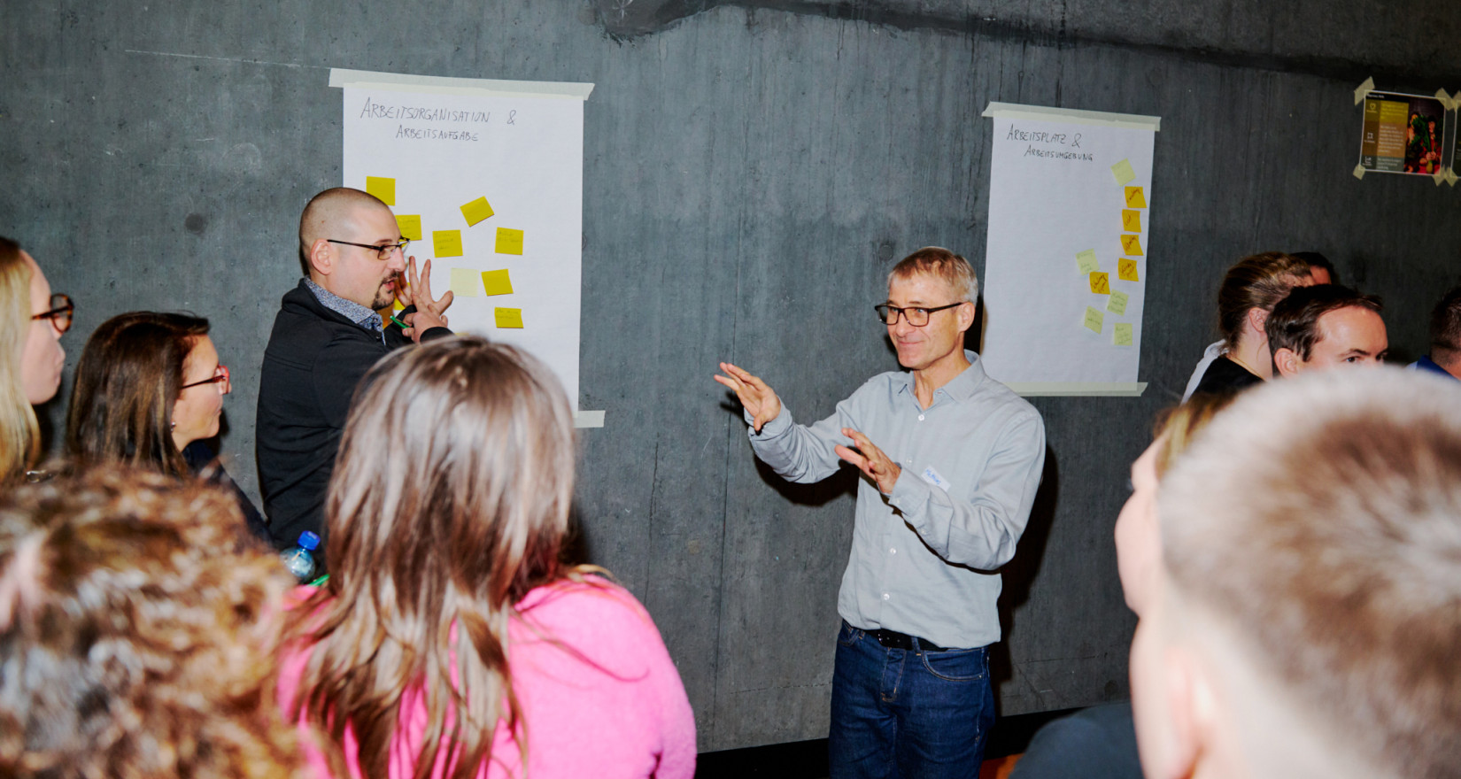 Personen beim Brainstorming vor einer Wand mit Post-its