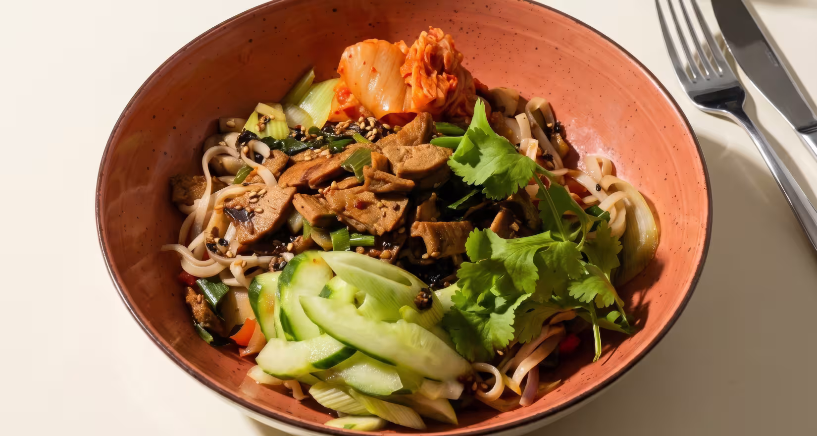 Oranger Teller mit Bibimbap auf einem Tisch