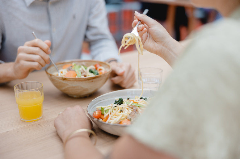 zwei Personen essen asiatische Bowls in der Mensa der Uni Bern