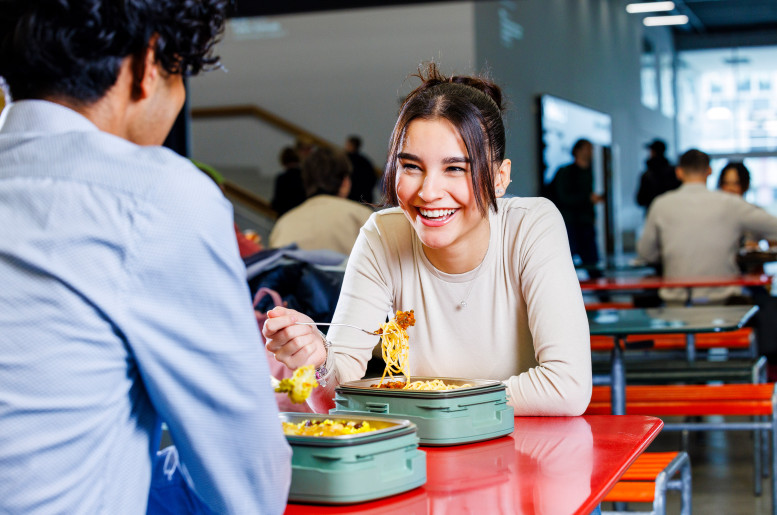 Junges Paar isst gemeinsam mitgebrachtes Essen