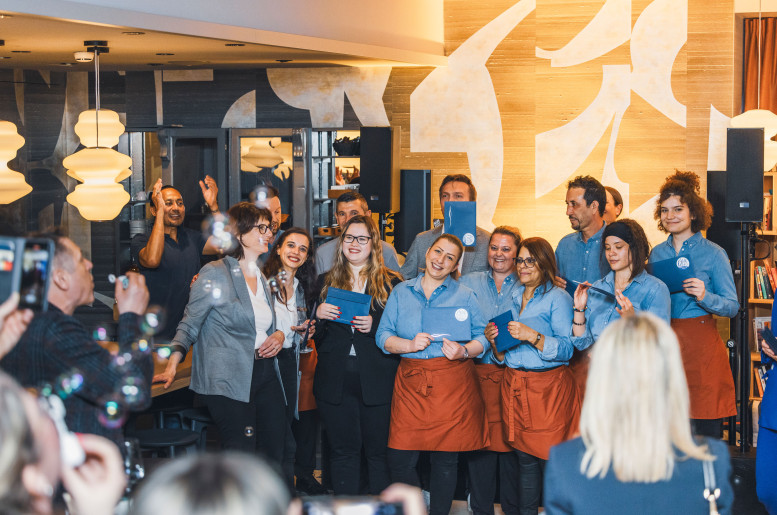 Gastronomieteam in blau-orangen Uniformen