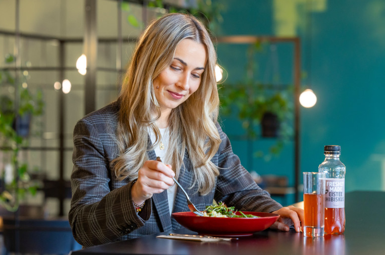 Frau isst in einem begrünten Restaurant