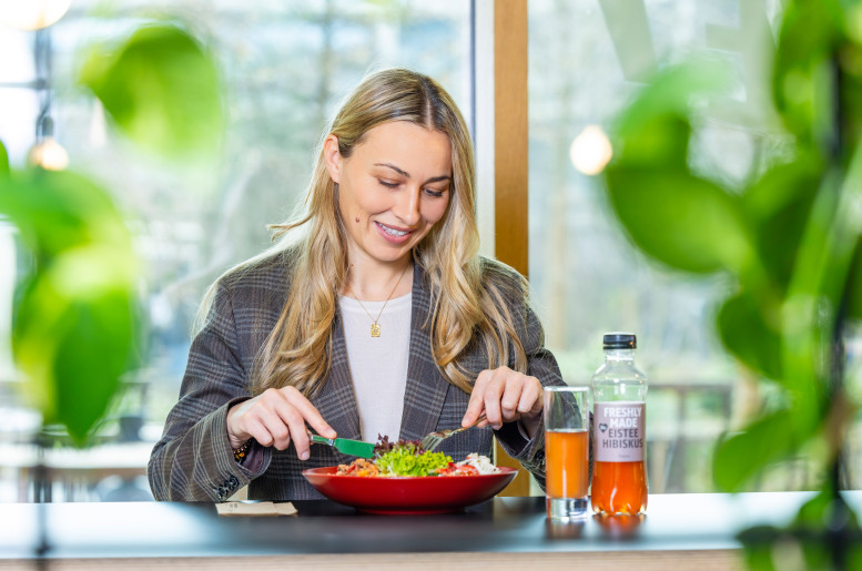 Blonde Frau sitzt in einem Restaurant und isst