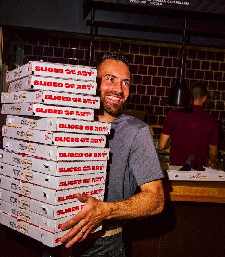 Mann in einem Restaurant hält einen Stapel Pizzakartons