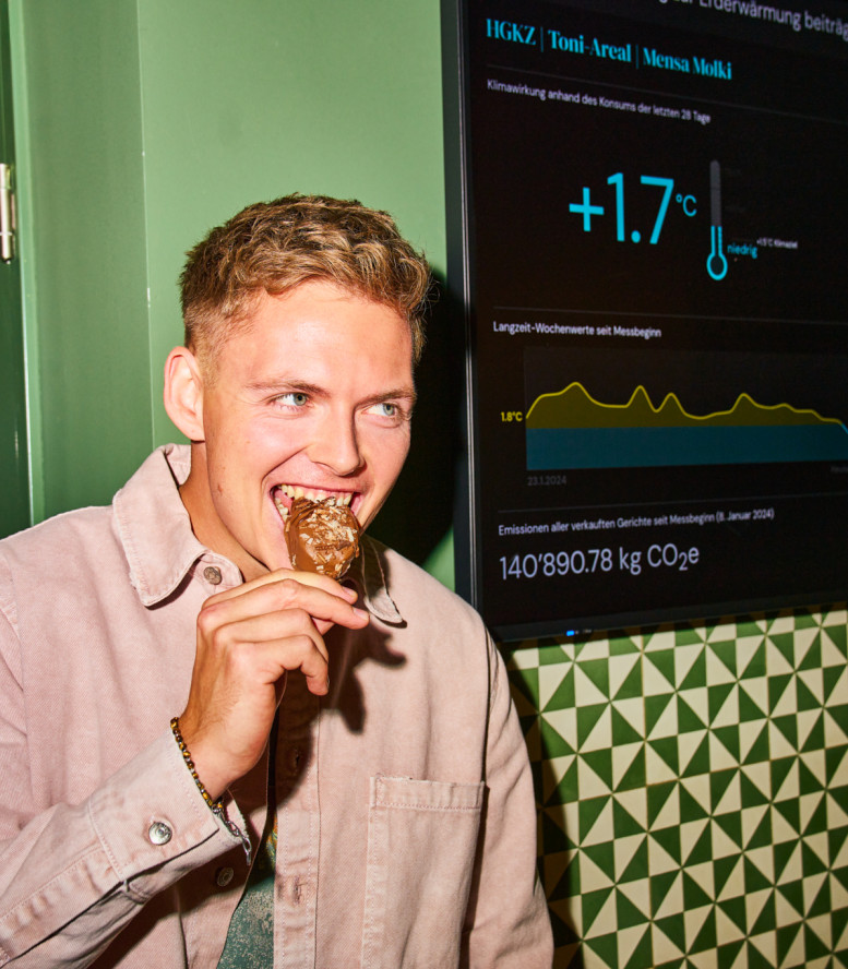 Junger Mann steht vor einem Screen mit Klimawirkung