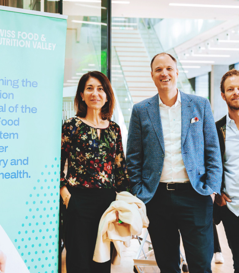 Drei Personen stehen vor einem Banner von SFNV