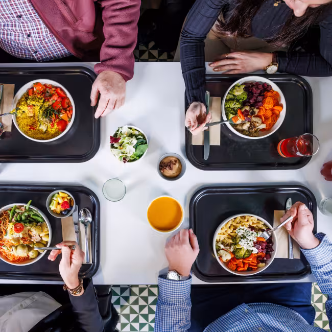 Tisch von oben mit vier Tableaus und Essen darauf