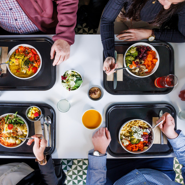 Tisch von oben mit vier Tableaus und Essen darauf
