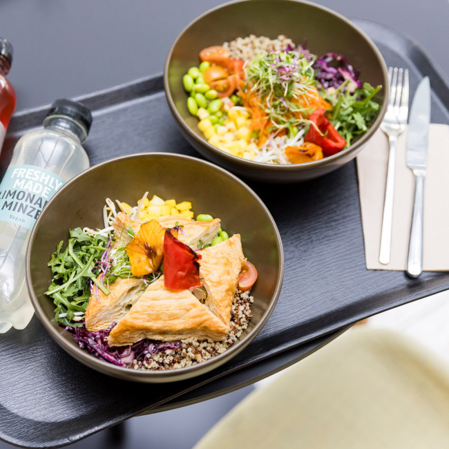 Zwei Bowls mit frischem Lunch auf einem Plateu mit Getränken