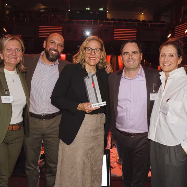Fünf Personen auf einer Bühne mit einem Award