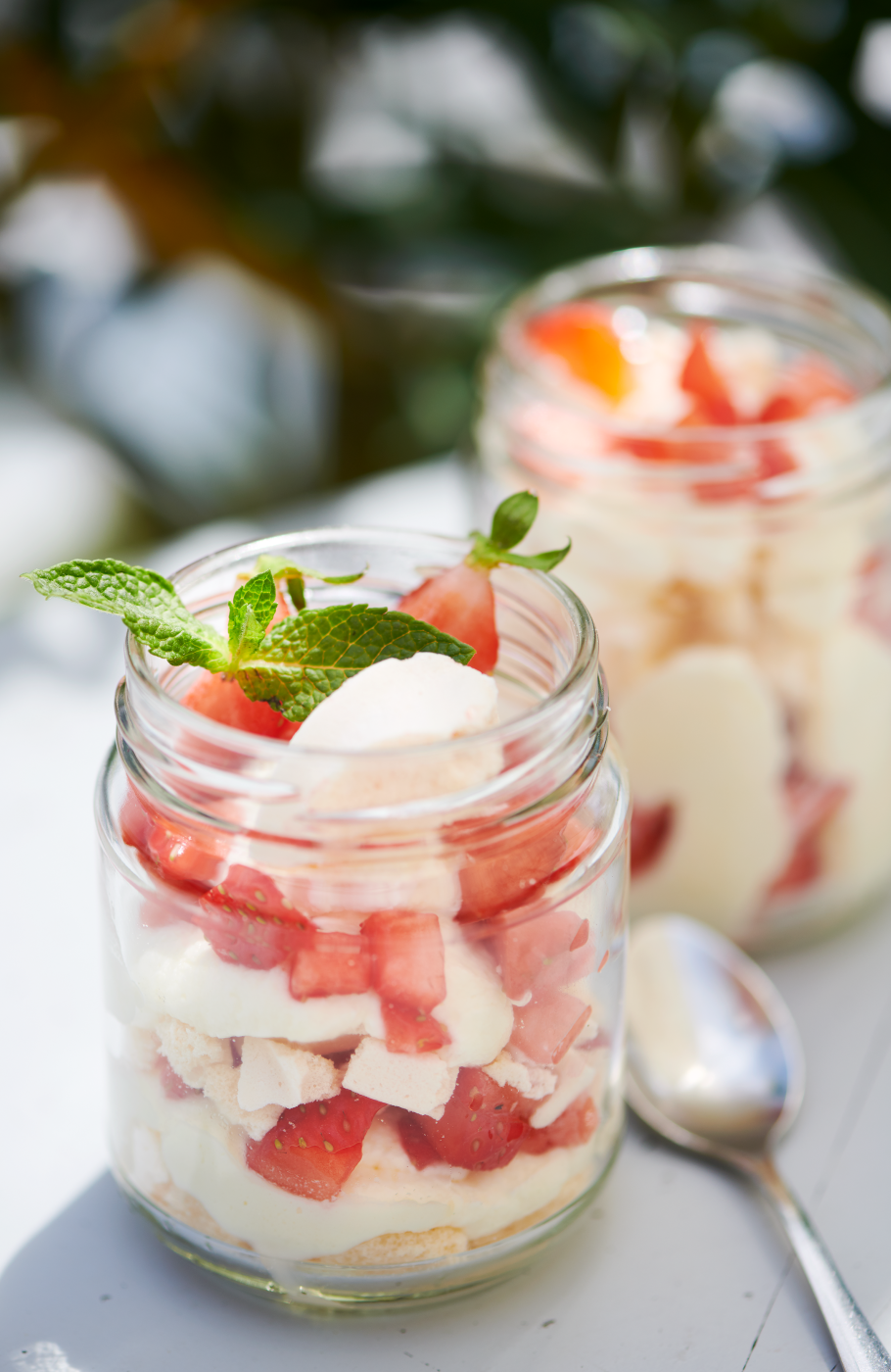 Dessertkreation mit weisser Creme und Erdbeereb, geschichtet im Glas